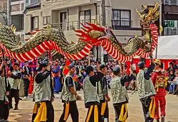 Men carrying a long dragon.