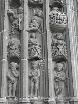 One of the carved voussure/piédroits decorating the outer rim of the entrance arch to the south porch at the église Saint-Thuriau (the lower level stones are known as piédroits and those wedge-shaped blocks higher up are voussures-voussoir in English). The scenes carved by Bastien Prigent include Adam and Eve's fall from grace, their expulsion from Eden, Adam working the land, Eve carrying Abel wrapped in swaddling clothes and Cain in a cradle, Cain and Abel making their sacrifice, Abel's murder, Noah cultivating his vine and picking the grapes and finally Noah's drunkenness and Cham's transgression. In this photograph the sculptures include Noah's ark crammed with people and animals, and Adam and Eve now aware of their nudity having tasted the forbidden fruit. They cover their private parts in shame