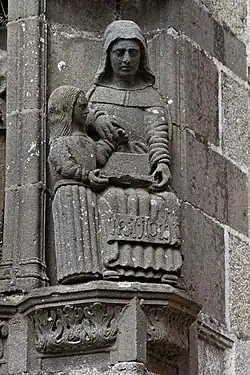Saint Anne teaches the Virgin Mary to read. One of the sculptures in the buttresses supporting the arch