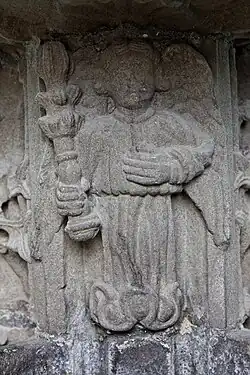 Figure on the stoup in the porch of Landivisiau's Église Saint-Thuriau. An angel holds a bottlebrush