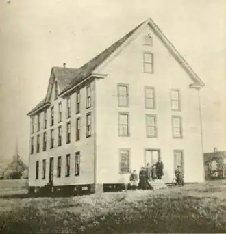 Photo of three-story wooden frame building, side profile