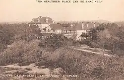 A black-and-white postcard of a hotel in a forest
