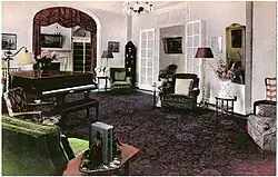Formal room with piano, chairs, and arched entryway