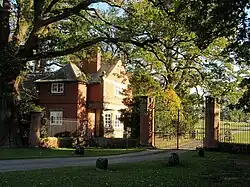 Lodge, among trees, at the entrance to a country house