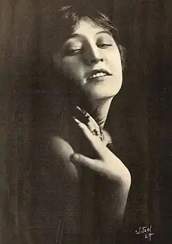 A young white woman, one hand on her shoulder