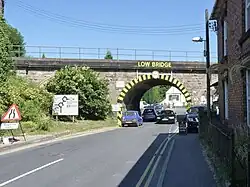 Large &quot;low bridge&quot; sign with hazard marking on the bridge