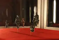 dark-colored stone figurines displayed inside transparent case