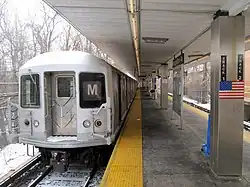An "M" shuttle train at Middle Village–Metropolitan Avenue during reconstruction of the Myrtle Avenue Line's junction with the BMT Jamaica Line