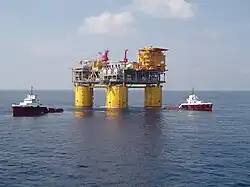 Colour photo of the Magnolia oil platform with two ships next to it