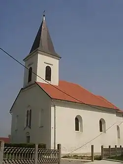 A chapel in the village in front of a blue sky.