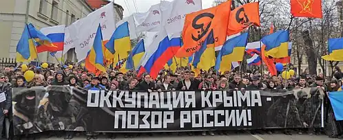 Protesters holding a banner saying: occupation of the Crimea is a shame of Russia