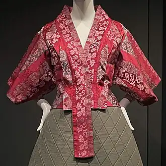 Red short jacket with kimono-inspired embroidery and pattern, on mannequin