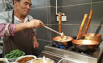 Mixian (米线) rice noodles being cooked in copper pots (铜锅), China