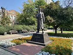 A statue of a moustached man, wearing a greatcoat and a peaked cap.
