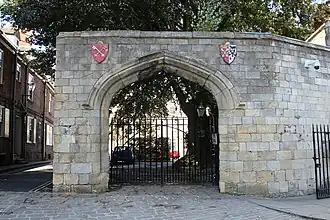 The gate to the lodge, beside Precentor's Court. The shields of arms belong to St Peter and the Deanery of York
