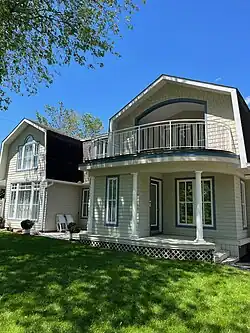 a) Arched, inset upper balcony, b) Front verandah (built, 1982)