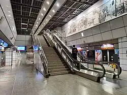 Platform level of Clarke Quay station, with escalators and stairs leading up from the platform level to the concourse