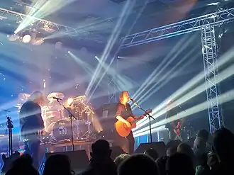 New Model Army performing in 2022, left to right: Dean White (keyboards and guitar), Michael Dean (drums), Justin Sullivan (vocals and guitar), Ceri Monger (bass).
