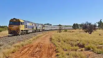 Train rounding a bend through scrubland