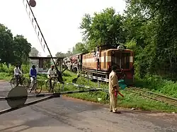 Train at grade crossing, with bicyclists waiting to cross