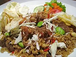 Nasi Goreng, a classic Indonesian fried rice dish, cooked with vegetables, meat, and bumbu (seasoning).
