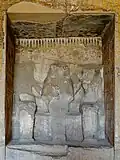 The northern wall of Paheri's tomb with a damaged niche featuring three statues of Paheri, his wife Henuterneheh, and his mother Kemi