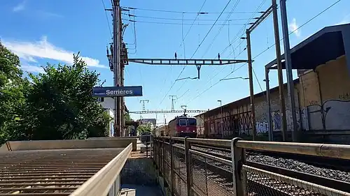 Red train passing side platform