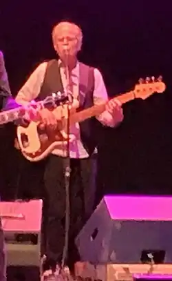 Jim Photoglo playing a bass guitar.