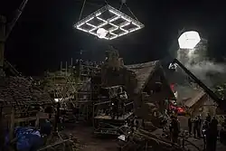 Picture of a lighting grid hanging over a village film set at night