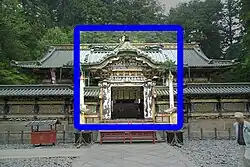 A Chinese style connected on either side to a see-through fence.