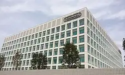 The headquarters of Nintendo since 2010, pictured in 2014. The company's gray logo is seen on the building in the top right.