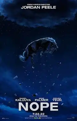 A horse, alien plush toys, and various concession stand foods levitate towards an ominous cloud in the night sky.