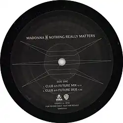 Side one of a black record with a symbol covering the surface and letters mentioning the two versions of the song