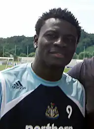 Head and upper torso of a young black man wearing a sports shirt with a number nine on the chest.