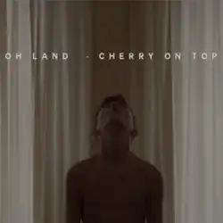 A young boy without a shirt is facing upwards towards the title of the song.