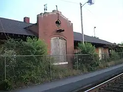 A single-story brick train station in disrepair
