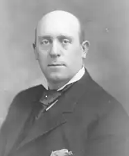 A black-and-white photo of a bald, middle-aged man