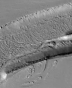 The Olympica Fossae, as seen by HiRISE. Click on image to see rock layers in wall.