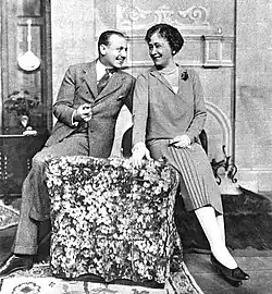 youngish white man and middle-aged white woman seated, affectionately close