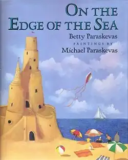 A tall sand castle at a beach with a blue sky behind it