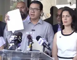 Several people standing at a podium holding up pieces of paper