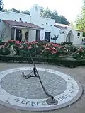 Sundial at the ranch next to a bed of roses.