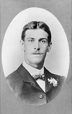 A formal head-and-shoulders portrait of a man. He is well groomed, and is wearing a suit.
