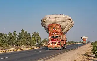 Two decorated trucks on Pakistan's N-5 National Highway.