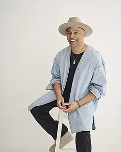 Portrait of Sam Prince leaning on stool