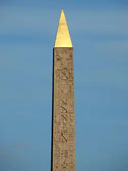 Hieroglyphs on the upper obelisk. The Pharaoh on his throne is portrayed at the top
