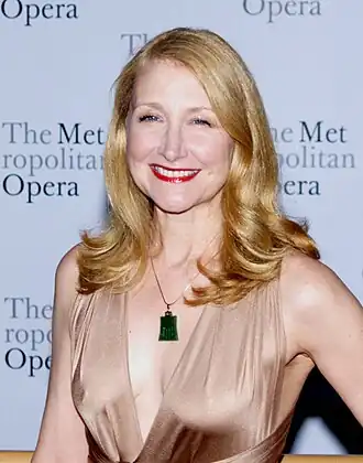 Photo of Patricia Clarkson smiling at the camera while wearing a rose gold dress
