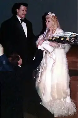 Elderly Mae West standing next to Paul Novak at a social event, 1978