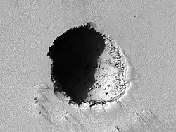 HiRISE image of a 180 m wide lava tube skylight on the southeast flank of Pavonis Mons.