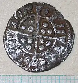 dull, silver coin with a cross in the centre